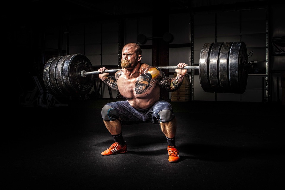 Muscular Guy with Beard Barbell Squatting