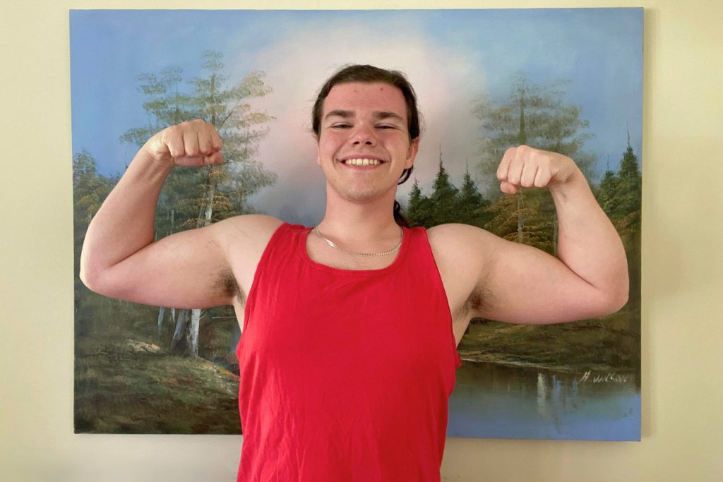 Image of Greg smiling and flexing