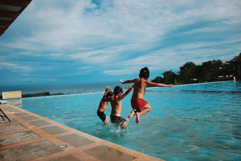 Kids jumping into a pool