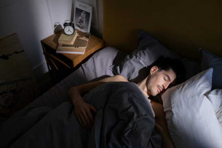 Man sleeping in bed with sunlight on his face