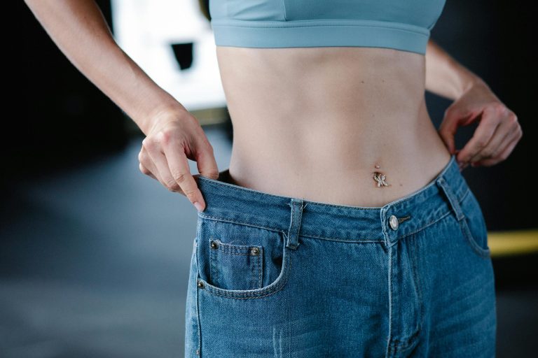 Woman using her hands to hold up a pair of jeans.
