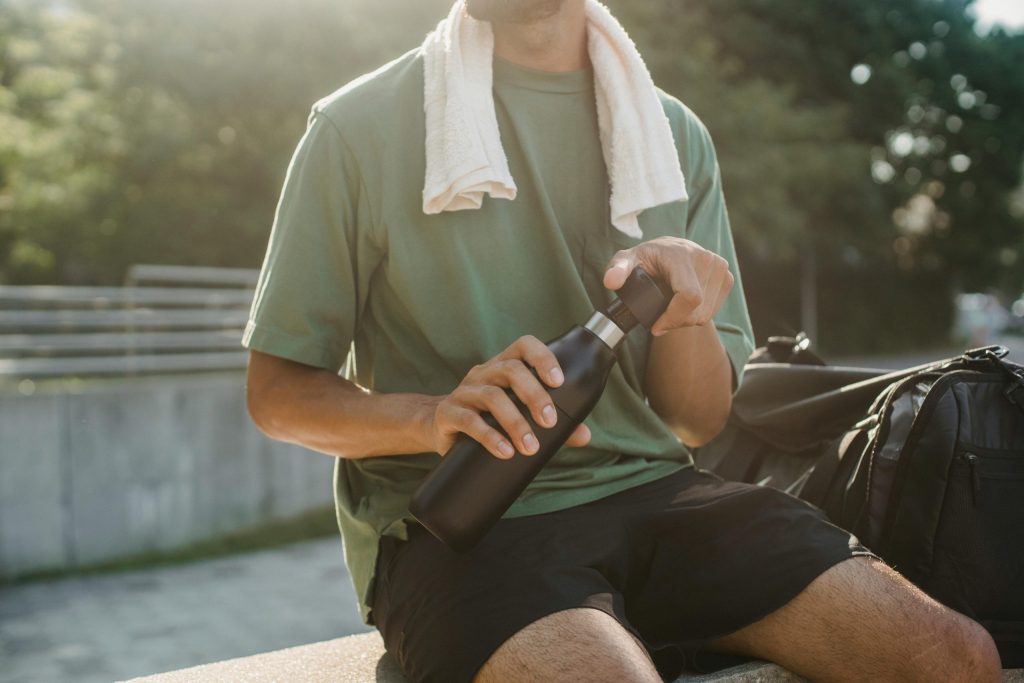 Man sitting down with a water bottle in hand.